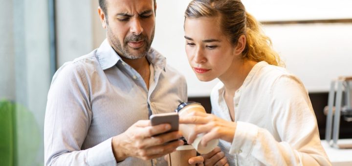 Une personne regarde son téléphone pendant que son partenaire l’observe avec insistance.